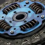 Primer plano de un disco de embrague de coche con resortes y plato de presión azul.