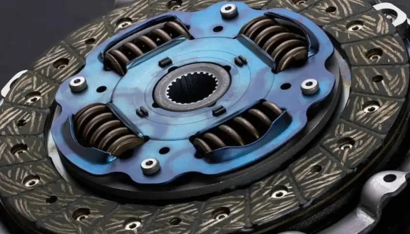 Primer plano de un disco de embrague de coche con resortes y plato de presión azul.